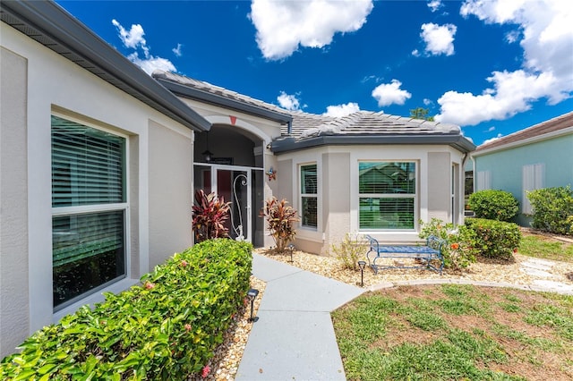 26254 Stillwater Cir, Punta Gorda, FL 33955 - doorway to property featuring stucco siding and a tiled roof