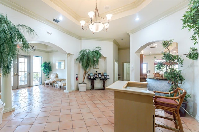 26254 Stillwater Cir, Punta Gorda, FL 33955 - kitchen with arched walkways, crown molding, plenty of natural light, a chandelier, and light tile patterned flooring