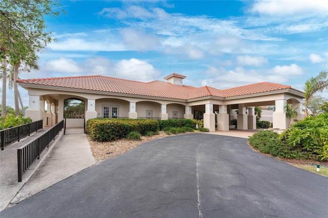 26254 Stillwater Cir, Punta Gorda, FL 33955 - mediterranean / spanish-style house featuring stucco siding, a tile roof, asphalt driveway, and a chimney