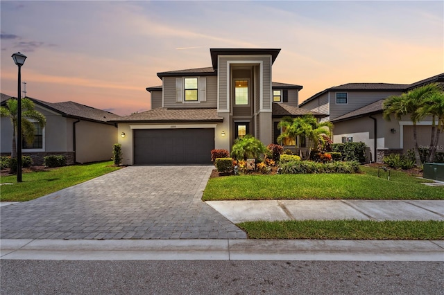11105 Balfour St E, Venice, FL 34293 - view of front of home featuring decorative driveway, a lawn, a garage, and stucco siding
