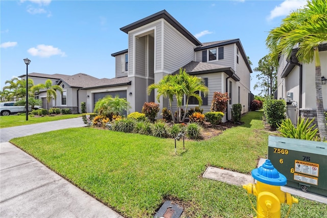 11105 Balfour St E, Venice, FL 34293 - view of front of property featuring a front lawn, driveway, a garage, and a shingled roof
