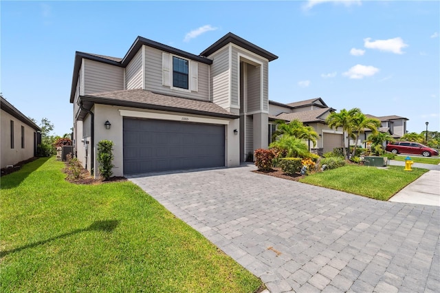 11105 Balfour St E, Venice, FL 34293 - view of front of house featuring decorative driveway, a front lawn, a garage, stucco siding, and roof with shingles