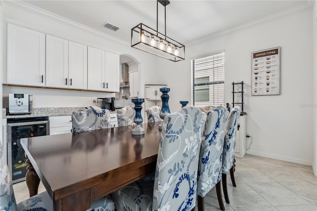 11105 Balfour St E, Venice, FL 34293 - dining area featuring wine cooler, crown molding, arched walkways, and light tile patterned floors