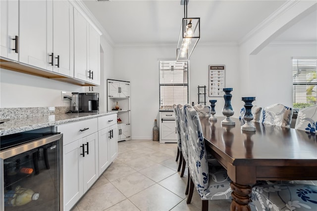 11105 Balfour St E, Venice, FL 34293 - dining room featuring wine cooler, crown molding, light tile patterned flooring, and arched walkways