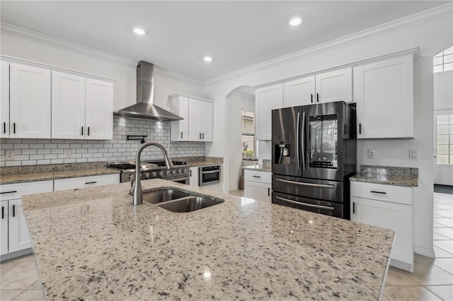 11105 Balfour St E, Venice, FL 34293 - kitchen featuring refrigerator with ice dispenser, wall chimney exhaust hood, arched walkways, white cabinets, and plenty of natural light