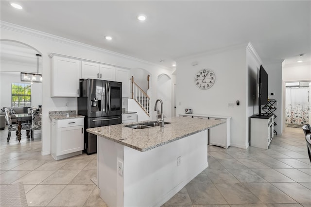 11105 Balfour St E, Venice, FL 34293 - kitchen with fridge with ice dispenser, arched walkways, ornamental molding, white cabinets, and light stone counters