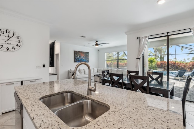 11105 Balfour St E, Venice, FL 34293 - kitchen featuring ceiling fan, ornamental molding, light tile patterned flooring, white cabinets, and open floor plan