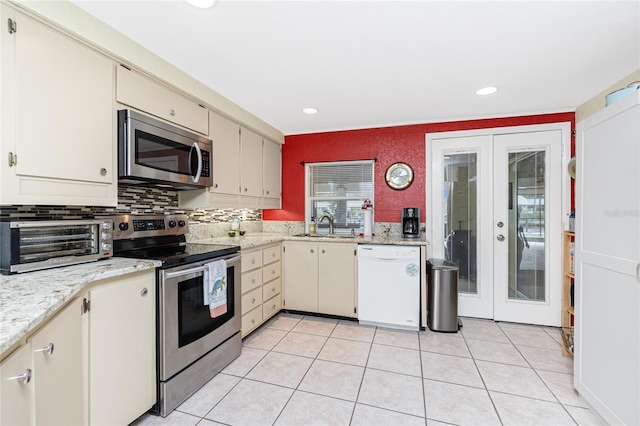 4051 Rock Creek Dr, Port Charlotte, FL 33948 - kitchen featuring stainless steel appliances, french doors, light tile patterned flooring, backsplash, and recessed lighting