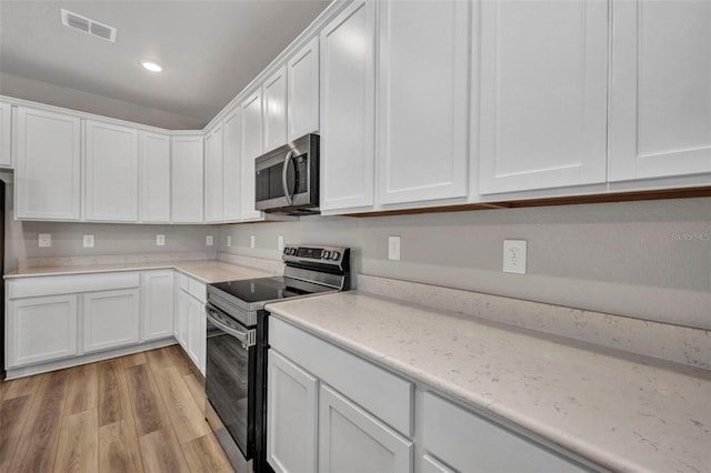 16848 Canopy Garden Dr, Port Charlotte, FL 33953 - kitchen with appliances with stainless steel finishes, white cabinets, light wood-style floors, and recessed lighting