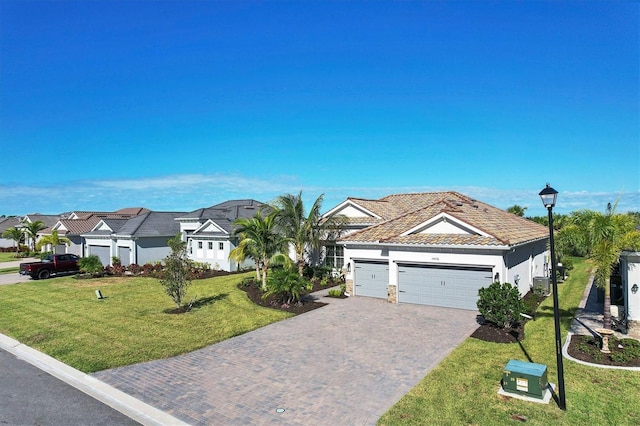 14436 Ponce De Leon Trl, Port Charlotte, FL 33981 - view of front facade featuring stucco siding, a tile roof, decorative driveway, an attached garage, and a front yard