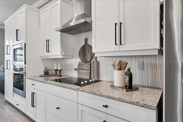 14436 Ponce De Leon Trl, Port Charlotte, FL 33981 - kitchen featuring wall chimney range hood, appliances with stainless steel finishes, white cabinetry, light stone counters, and decorative backsplash