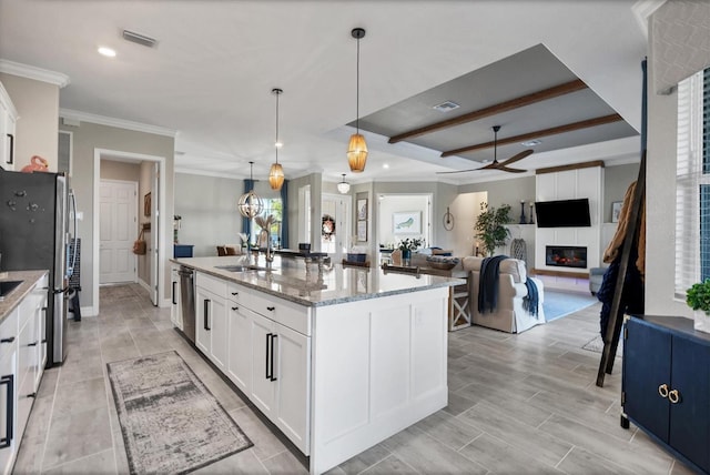 14436 Ponce De Leon Trl, Port Charlotte, FL 33981 - kitchen with a ceiling fan, a fireplace, appliances with stainless steel finishes, white cabinets, and a kitchen island with sink