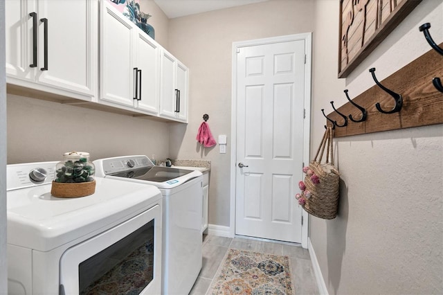 14436 Ponce De Leon Trl, Port Charlotte, FL 33981 - laundry room featuring washing machine and dryer, cabinet space, and light wood finished floors