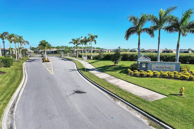 14436 Ponce De Leon Trl, Port Charlotte, FL 33981 - view of asphalt street featuring curbs, traffic signs, a residential view, sidewalks, and a gated entry