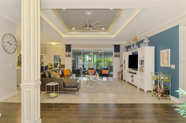 6444 Alhambra Ave, North Port, FL 34291 - living area featuring decorative columns, ceiling fan, a tray ceiling, ornamental molding, and light wood finished floors