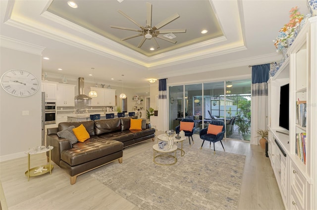 6444 Alhambra Ave, North Port, FL 34291 - living room featuring a ceiling fan, a tray ceiling, crown molding, light wood-style floors, and recessed lighting