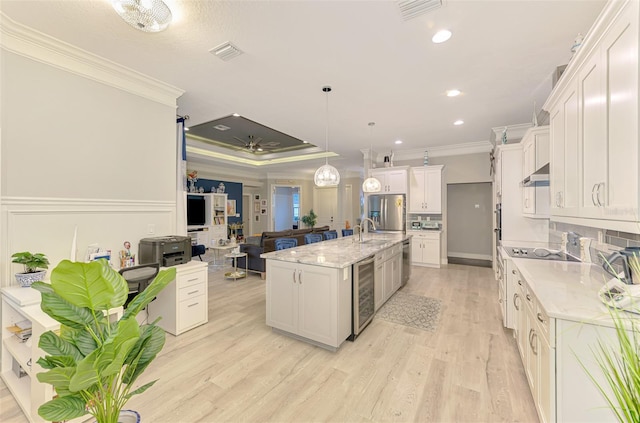 6444 Alhambra Ave, North Port, FL 34291 - kitchen with crown molding, white cabinets, under cabinet range hood, wine cooler, and light wood-type flooring