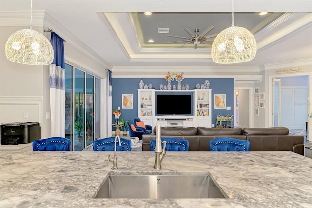 6444 Alhambra Ave, North Port, FL 34291 - kitchen featuring light stone countertops, crown molding, a chandelier, a raised ceiling, and hanging light fixtures