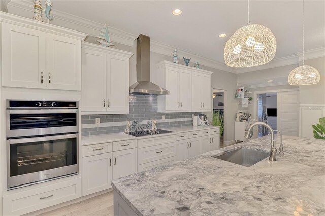 6444 Alhambra Ave, North Port, FL 34291 - kitchen featuring wall chimney exhaust hood, stainless steel double oven, black electric stovetop, white cabinetry, and light stone counters