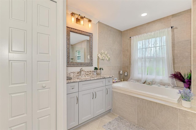 6444 Alhambra Ave, North Port, FL 34291 - full bath with vanity, a garden tub, tile patterned floors, and tile walls