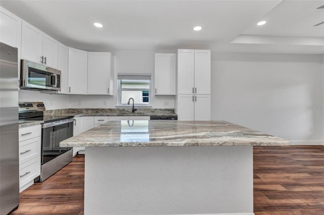 419 Carmalita St, Punta Gorda, FL 33950 - kitchen with appliances with stainless steel finishes, dark wood-style flooring, a center island, recessed lighting, and light stone counters