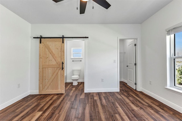 419 Carmalita St, Punta Gorda, FL 33950 - unfurnished bedroom with dark wood-style flooring, a barn door, and multiple windows