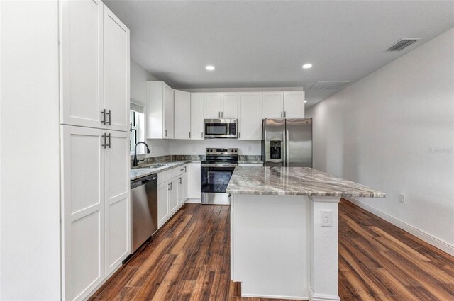 419 Carmalita St, Punta Gorda, FL 33950 - kitchen featuring appliances with stainless steel finishes, a kitchen island, light stone countertops, white cabinetry, and recessed lighting