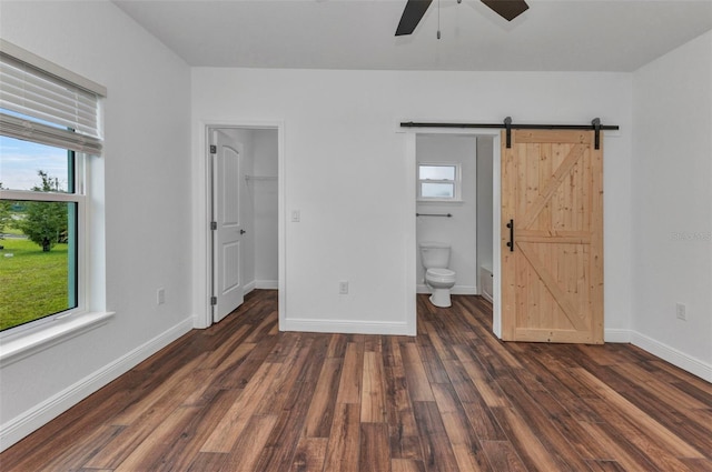 419 Carmalita St, Punta Gorda, FL 33950 - unfurnished bedroom with a barn door, multiple windows, wood finished floors, and a spacious closet