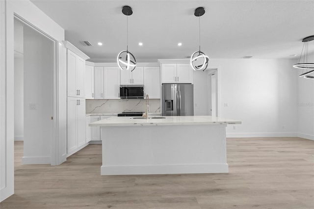 17156 Eugene Ave, Port Charlotte, FL 33954 - kitchen featuring stainless steel refrigerator with ice dispenser, recessed lighting, white cabinets, decorative backsplash, and an island with sink