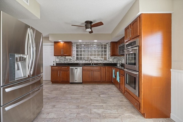 2309 Conway Blvd, Port Charlotte, FL 33952 - kitchen featuring appliances with stainless steel finishes, a ceiling fan, dark countertops, and brown cabinets