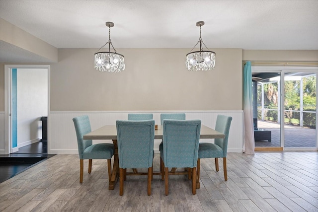 2309 Conway Blvd, Port Charlotte, FL 33952 - dining area featuring a wainscoted wall, a chandelier, and wood finished floors