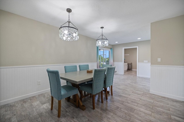 2309 Conway Blvd, Port Charlotte, FL 33952 - dining room featuring a wainscoted wall, wood finished floors, and a chandelier
