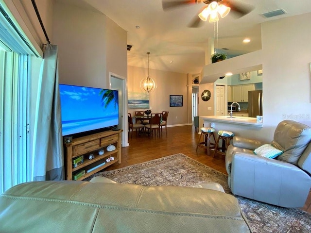 24132 Buckingham Way, Punta Gorda, FL 33980 - living area featuring dark wood-style flooring, ceiling fan, vaulted ceiling, and a chandelier