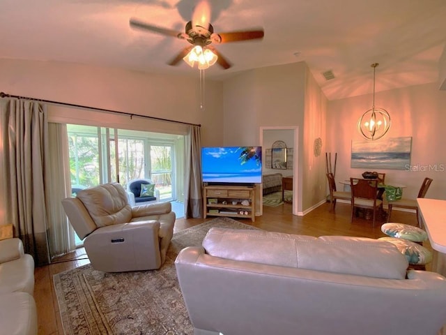 24132 Buckingham Way, Punta Gorda, FL 33980 - living room featuring a chandelier, wood finished floors, vaulted ceiling, and a ceiling fan
