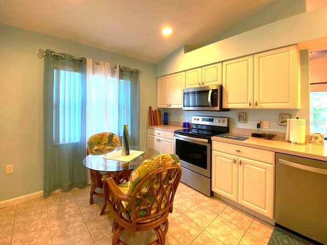 24132 Buckingham Way, Punta Gorda, FL 33980 - kitchen featuring stainless steel appliances, lofted ceiling, light countertops, light tile patterned floors, and recessed lighting