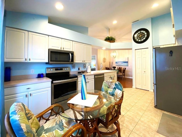 24132 Buckingham Way, Punta Gorda, FL 33980 - kitchen with appliances with stainless steel finishes, light tile patterned floors, white cabinets, light countertops, and recessed lighting