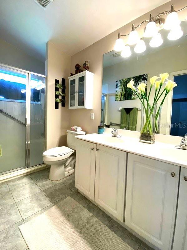 24132 Buckingham Way, Punta Gorda, FL 33980 - full bath with a shower stall, double vanity, and tile patterned floors