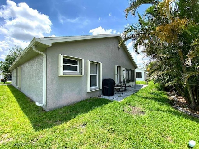 24132 Buckingham Way, Punta Gorda, FL 33980 - rear view of property featuring stucco siding, a patio, and a yard