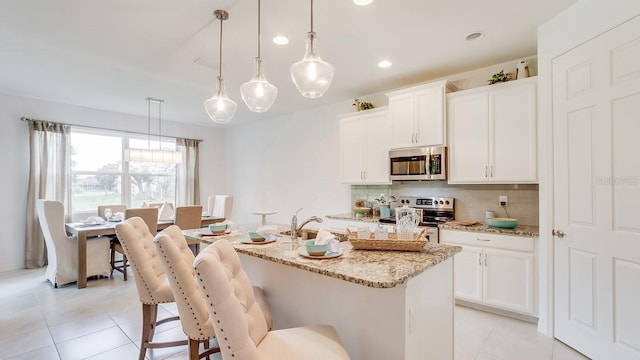 2308 Oberon Ln, Punta Gorda, FL 33983 - kitchen with stainless steel appliances, decorative backsplash, light tile patterned flooring, light stone counters, and recessed lighting