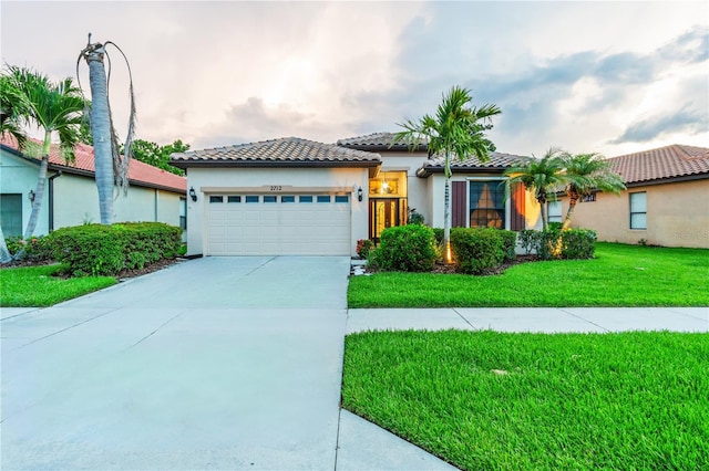 2712 Arugula Dr, North Port, FL 34289 - mediterranean / spanish-style home with an attached garage, concrete driveway, a front lawn, stucco siding, and a tile roof