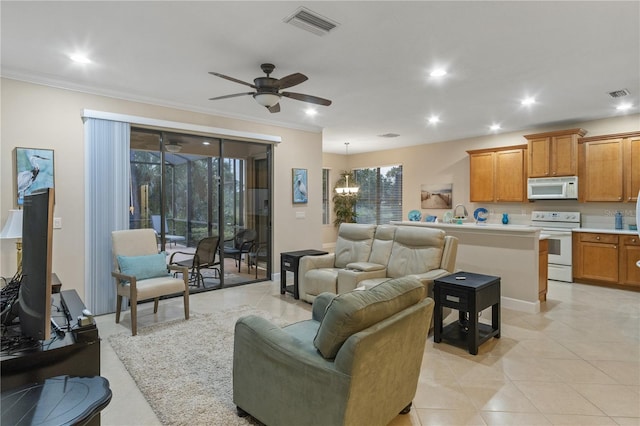 2712 Arugula Dr, North Port, FL 34289 - living room featuring ceiling fan, recessed lighting, ornamental molding, light tile patterned flooring, and a chandelier