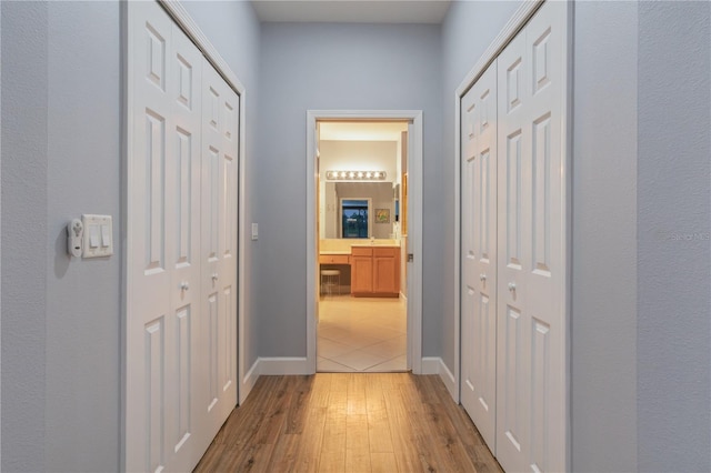 2712 Arugula Dr, North Port, FL 34289 - corridor featuring light wood-style floors and baseboards