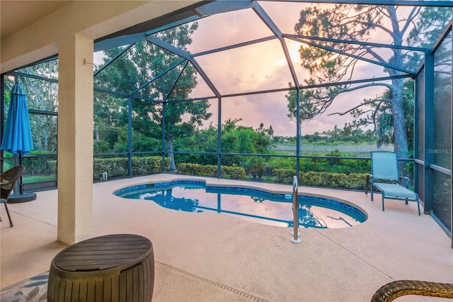2712 Arugula Dr, North Port, FL 34289 - pool at dusk featuring an outdoor pool, a patio, and glass enclosure
