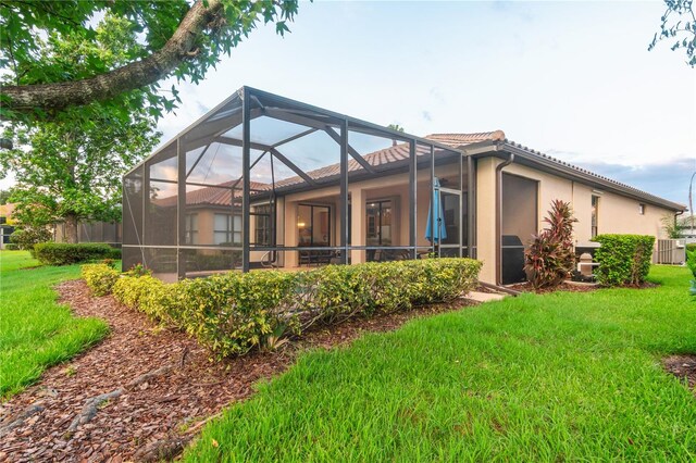2712 Arugula Dr, North Port, FL 34289 - back of property featuring a yard, a tile roof, stucco siding, and glass enclosure