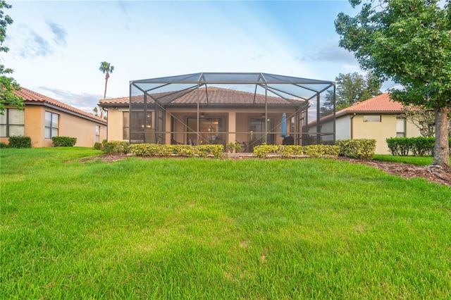 2712 Arugula Dr, North Port, FL 34289 - rear view of house with stucco siding, a yard, glass enclosure, and a tile roof