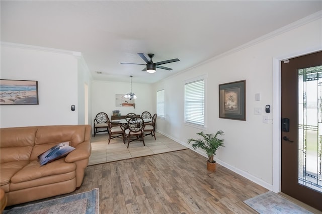 21539 Gladis Ave, Port Charlotte, FL 33952 - living room featuring a ceiling fan, crown molding, light wood-style flooring, and a chandelier