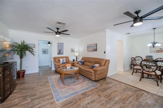 21539 Gladis Ave, Port Charlotte, FL 33952 - living area featuring a ceiling fan, ornamental molding, light wood finished floors, a chandelier, and a textured ceiling