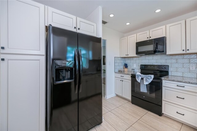 21539 Gladis Ave, Port Charlotte, FL 33952 - kitchen with black appliances, light stone countertops, white cabinets, and recessed lighting