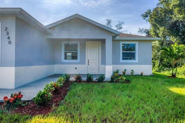 2340 Rushmore St, North Port, FL 34288 - view of front facade featuring stucco siding and a front yard