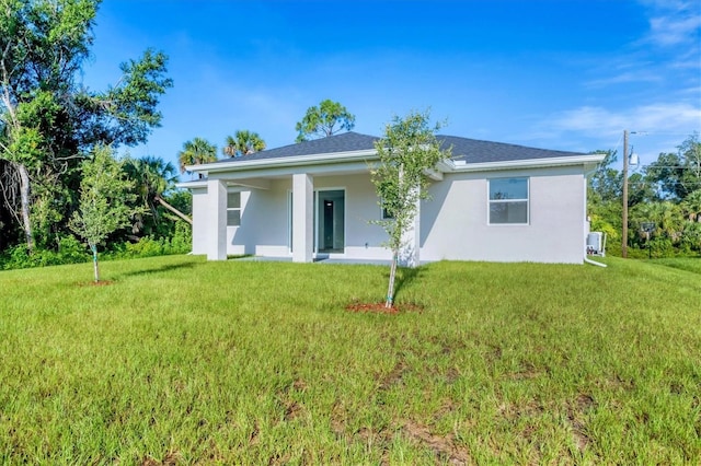 2340 Rushmore St, North Port, FL 34288 - back of house with stucco siding and a yard